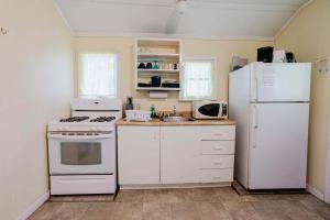 a kitchen with white appliances and a white refrigerator at 2-Bedroom Cottage #1 - Ambleside in Kawartha Lakes