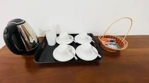 a tray with cups and saucers on a table at Aloria Sigiriya in Sigiriya