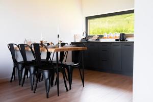 a dining room with a table and black chairs at Łyse Stodoły in Mordarka