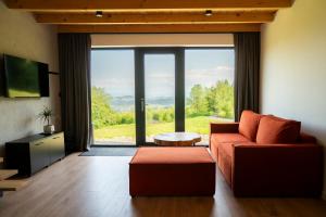 a living room with a couch and a large window at Łyse Stodoły in Mordarka