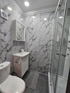 a bathroom with a white toilet and a shower at Mingles Suites in Il-Gżira