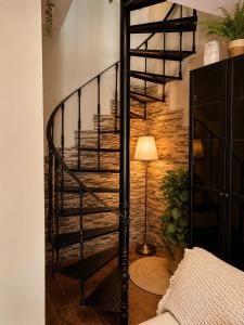 a spiral staircase in a living room with a lamp at Dúplex con Piscina y Terraza a 5 min de Sevilla in Camas +8 photos