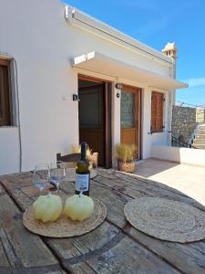 a bottle of wine and two glasses on a wooden table at Sidirounta Village Apartment in Sidiroúnta