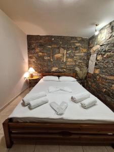 a bedroom with a bed with white towels on it at Sidirounta Village Apartment in Sidiroúnta