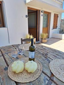 a bottle of wine and two glasses on a table at Sidirounta Village Apartment in Sidiroúnta