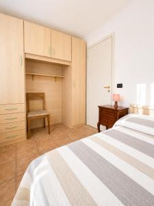a bedroom with a bed and a desk and a chair at PETRONIA TRILO VISTA MARE - Agenzia Cocal in Caorle