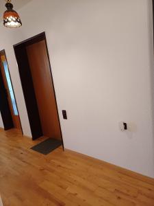 an empty room with a door and a wooden floor at Forstoase Deister in Bredenbeck