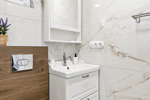 a bathroom with a white sink and marble walls at Rukkilille majutus in Herjava +43 photos
