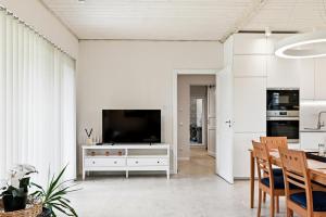 a living room with a television on a white cabinet at Rukkilille majutus in Herjava