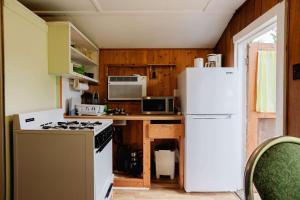 a kitchen with white appliances and a white refrigerator at 1-Bedroom Cottage #2 - Ambleside in Kawartha Lakes