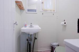a white bathroom with a sink and a toilet at 1-Bedroom Cottage #2 - Ambleside in Kawartha Lakes +12 photos