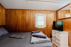 a bedroom with a bed and a tv on a dresser at 1-Bedroom Cottage #2 - Ambleside in Kawartha Lakes