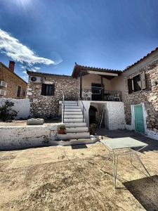 a house with a table in front of it at Leos Traditional Holiday House in Leonidio
