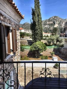 a balcony with a table and a view of a yard at Leos Traditional Holiday House in Leonidio