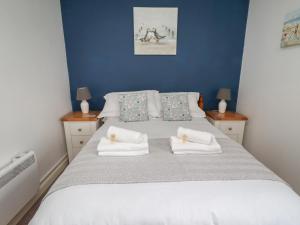 a bedroom with a large bed with two night stands at 22 Longstone Park in Chathill