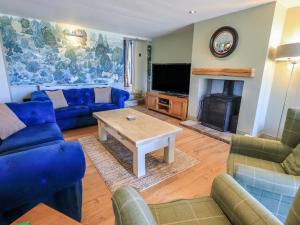 a living room with blue furniture and a fireplace at Fogga Croft in Skipton