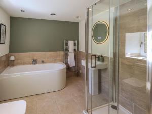 a bathroom with a tub and a glass shower at Fogga Croft in Skipton +39 photos