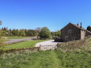 an old stone house on a hill with a wooden gate at Fogga Croft in Skipton