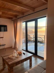 a living room with a table and a large window at Skidala Cottage in Batumi