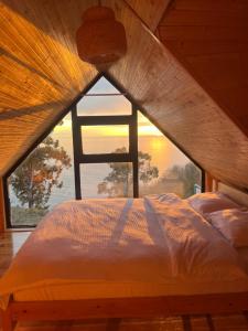 a bed in a room with a large window at Skidala Cottage in Batumi