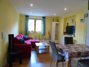 a living room with a red couch and a table at Ferienwohnung Csilla 2 in Oberweid