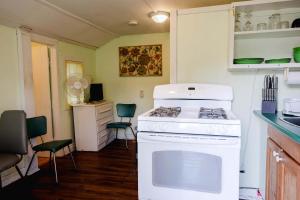 a kitchen with a stove and some chairs in it at Ambleside - 1-Bedroom Cottage #3 in Kawartha Lakes