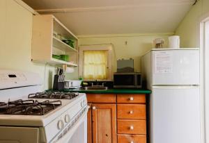 a kitchen with a stove and a white refrigerator at Ambleside - 1-Bedroom Cottage #3 in Kawartha Lakes +13 photos