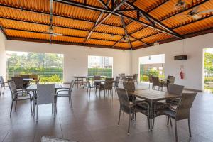 a dining room with tables and chairs and windows at La Jolla in Bejuco