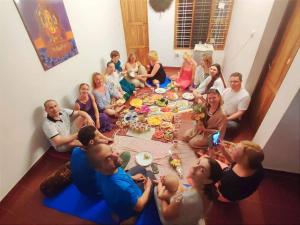 a group of people sitting around a table eating at Ganesh House Homestay in Kovalam