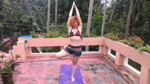 a woman in a bikini doing a yoga pose in a pool at Ganesh House Homestay in Kovalam
