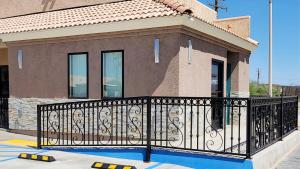 a house with a black iron fence in front at Magnuson Hotel Blythe in Blythe
