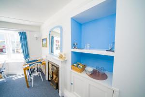 a blue and white room with a table and a mirror at Radcliffe Guest House in Ross on Wye +41 photos