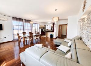 a living room with a couch and a dining room at Losinj Panorama Penthouse in Mali Lošinj