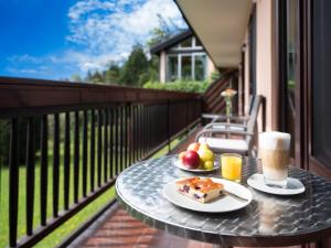 a table with two plates of food and drinks on a balcony at Hotel Haus Arenberg in Salzburg