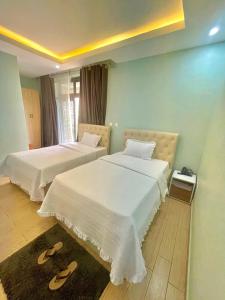 zwei Betten in einem Zimmer mit Hausschuhen auf dem Boden in der Unterkunft Ibigabiro Hotel in Kagano