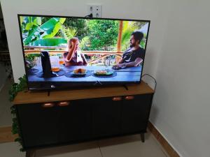 a flat screen tv sitting on top of a dresser at Casa no centro de Brumadinho in Brumadinho