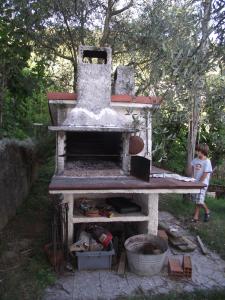 Ein Steinofen mit einem Jungen daneben. in der Unterkunft Cinque Terre Tra Il Filo Di Arianna in Riccò del Golfo di Spezia