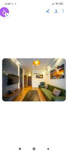 a living room with a green couch and a tv at Gori Apartaments in Gori