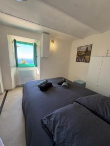 a bedroom with a large bed and a window at La maison jaune in Roquebrune-Cap-Martin