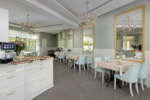 a dining room with white cabinets and tables and chairs at Chimera Spa Niechorze in Niechorze