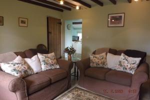 a living room with two brown couches and a table at Hillis Close Farm in Haltwhistle