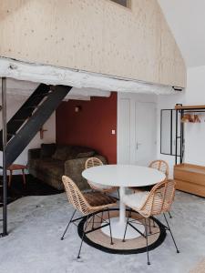 a room with a table and chairs and a couch at Charmant T2 - 4 couchages à 15mn de la mer in Merlevenez