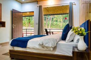 a bedroom with a bed with a vase of flowers at Earavat Resort in Rāmnagar