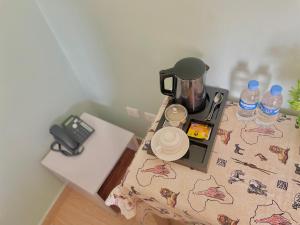 ein Tisch mit einer Kaffeemaschine und Wasserflaschen darauf in der Unterkunft Ibigabiro Hotel in Kagano