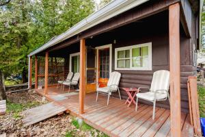 a cabin with chairs and a table on a deck at Ambleside - 2-Bedroom Cottage #4 in Kawartha Lakes