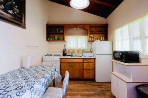 a small kitchen with a table and a refrigerator at Ambleside - 2-Bedroom Cottage #4 in Kawartha Lakes
