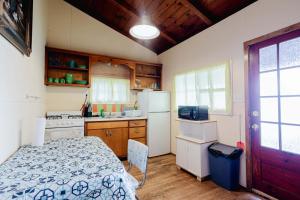 a kitchen with a bed and a white refrigerator at Ambleside - 2-Bedroom Cottage #4 in Kawartha Lakes +15 photos