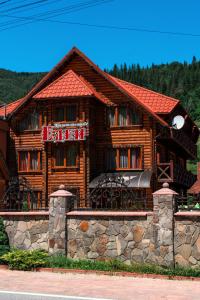a log building with a sign on it at Садиба "Едем" in Mykulychyn