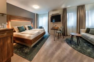a hotel room with a bed and a couch at Hotel Zur Schmiede in Radolfzell am Bodensee