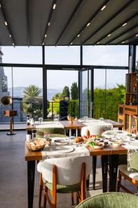a dining room with tables and chairs and large windows at Cesme Sarezya Luxury Boutique Hotel in Çeşme